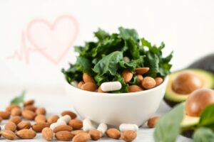 Magnesium capsules beside leafy greens and almonds, representing the role of magnesium in supporting healthy blood pressure.